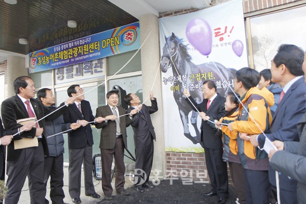 농어촌체험마을의 각종 사업을 통합지원하는 홍성농어촌체험관광지원센터가 군농업기술센터 내에 개소하고 본격 운영에 들어간다. 사진은 지난 22일 있었던 현판식에서 참석자들이 제막식에 앞서 기념촬영을 하고 있는 모습.