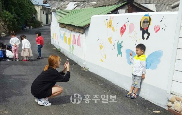 홍성읍 오관리 6구의 벽화마을에 지난 21일 인근 어린이집 원생 20명이 방문해 사진을 찍고 있다. 오관리 6구는 사슴, 학, 날개 등의 다양한 벽화로 유아들이 나들이 코스로 자주 들른다.