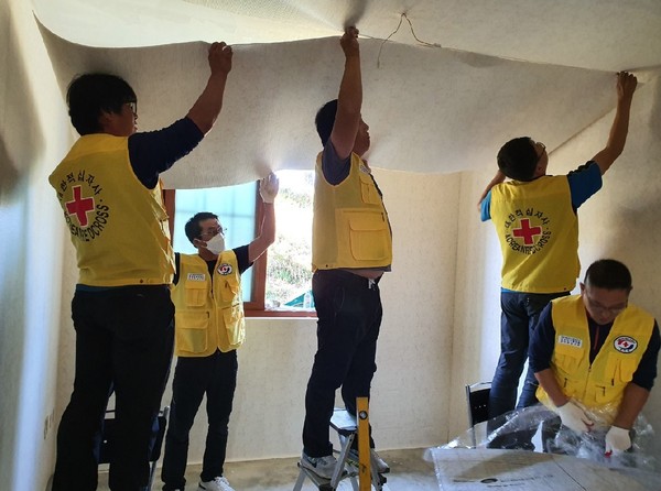 금마면의 한 다문화가정집 수리에 여념이 없는 '소나무봉사회' 회원들