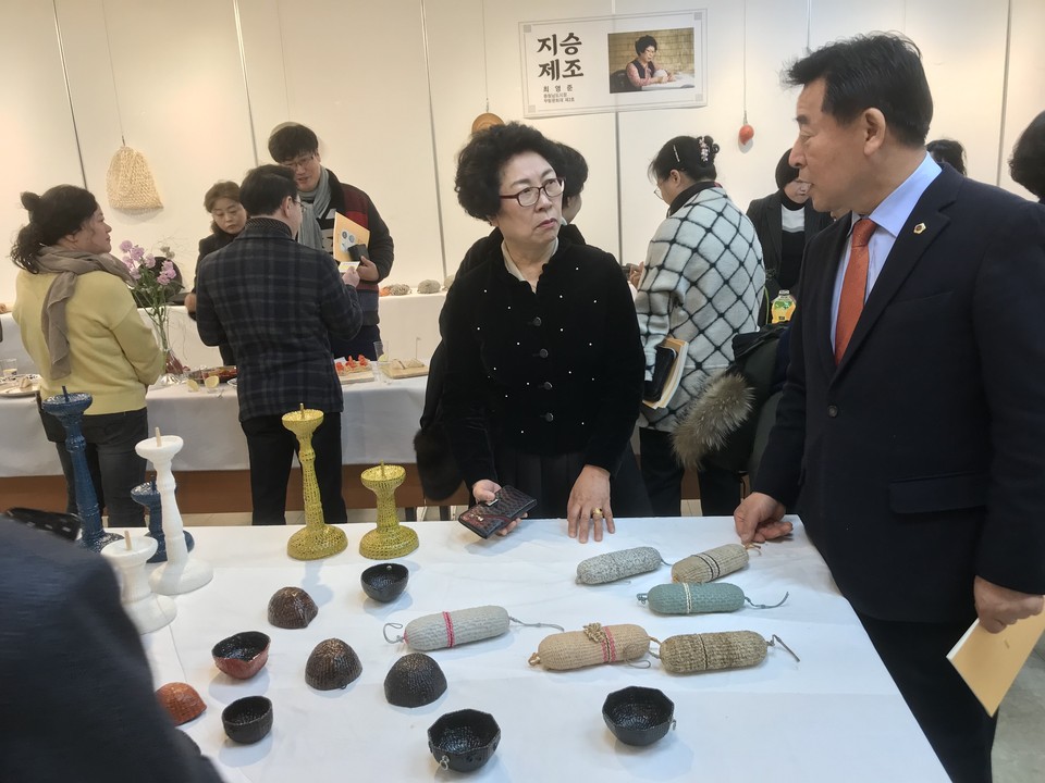 개막식이 있던 12월 2일 전시회를 찾은 충남도의회 이종화 의원에게 무형문화재 지승제조 기능보유자 최영준 씨가 자신이 직접 제작한 작품을 설명하고 있다.