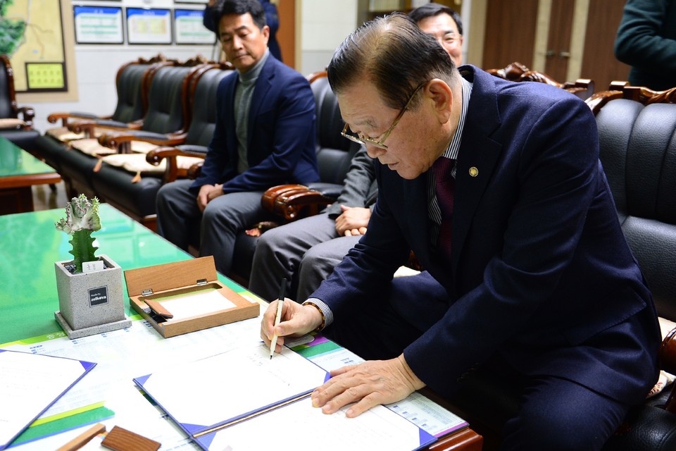 지난 3일 홍성군 청사이전 주민선호도조사를 위한 투표가 공정하고 투명하게 진행될 수 있도록 업무협약서를 체결하기 위해 서명하는 김석환 홍성군수.