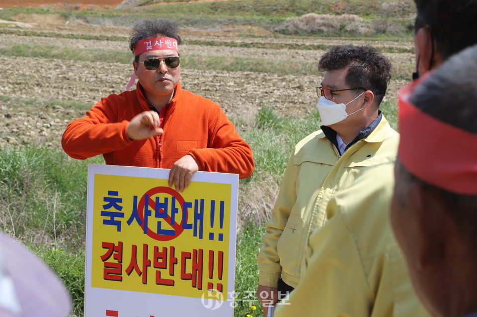 홍성군의회는 군정주요사업장 현장방문 대상지 중 한 곳인 장곡면 상송3리 마을을 찾아 축사신축을 반대하는 주민들의 민원을 청취하고 있다. 군의원들의 현장방문은 홍성군의회 제267회 임시회 기간 동안 진행되는 주요일정 중 하나다. 주민대책위 강문규 위원장이 김헌수 의장에게 "축사 신축으로 인해 그동안 공들인 마을만들기사업도 허사가 될 판이다"라고 강하게 호소하고 있다.