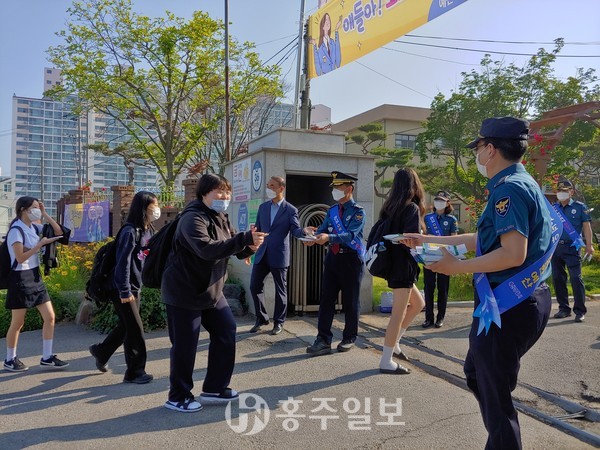 여성청소년계 소속 경찰관들이 예산여고 학생들에게 손소독제를 나눠주며 사이버성폭력 예방 캠페인을 실시하고 있다.