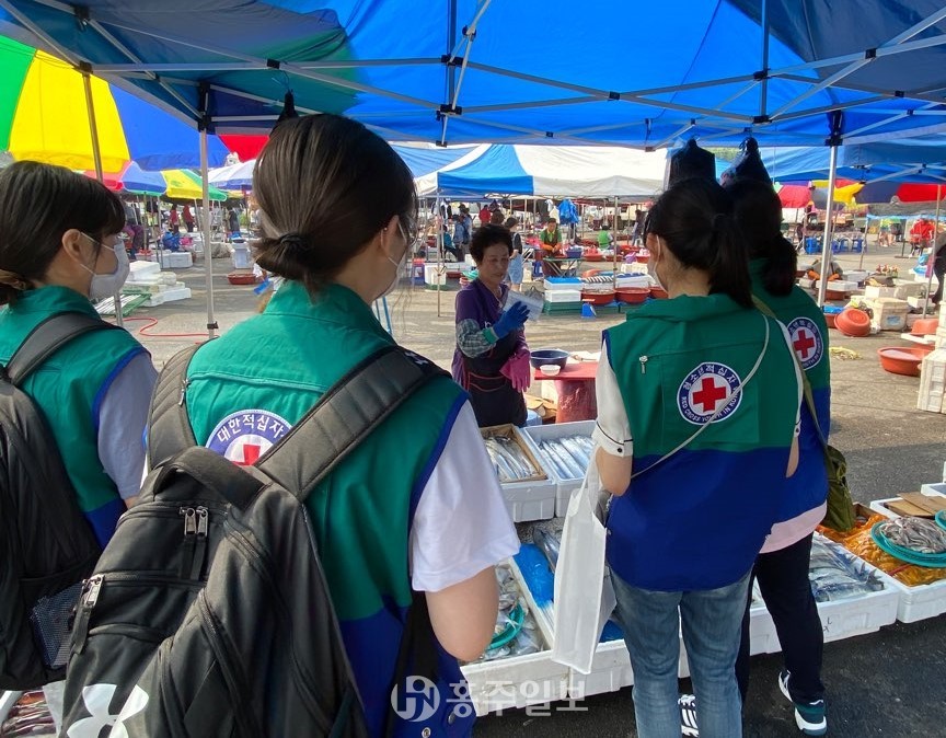 학생들이 예산읍 전통시장에서 마스크를 나눠주고 있다.