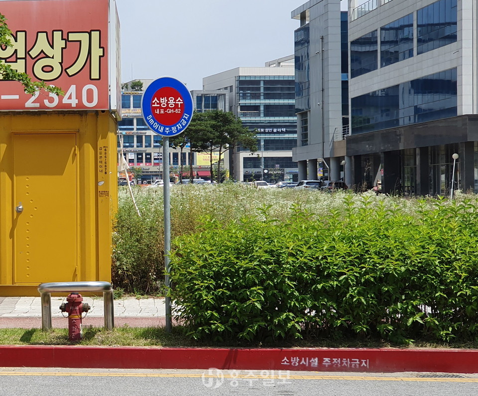 소방시설 주변 불법 주·정차금지 안내 표지판과 적색노면표시.