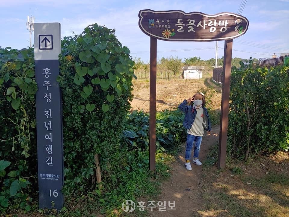 지난 9일 ‘제6회 홍주성천년여행길 걷기행사’에 참여한 한 어린이가 들꽃사랑방 입구에서 사진을 촬영하고 있다.