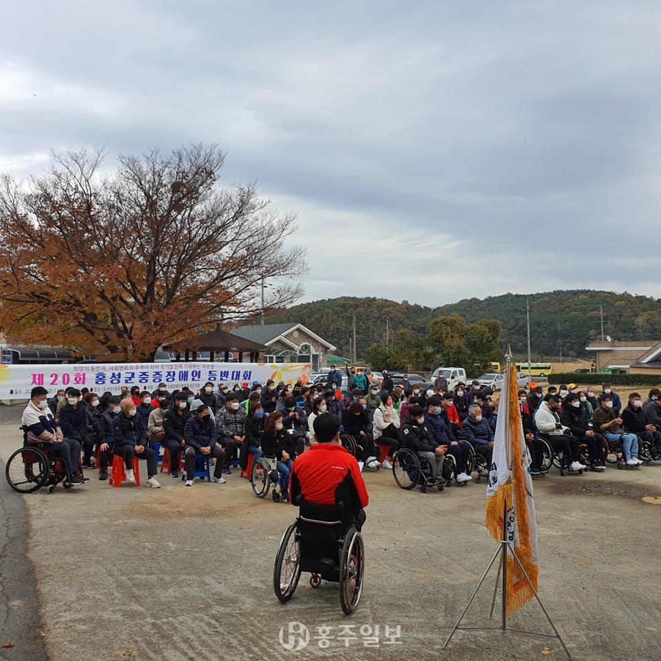 휠체어등반대회에 참여한 100여명의 사람들이 모여있다.