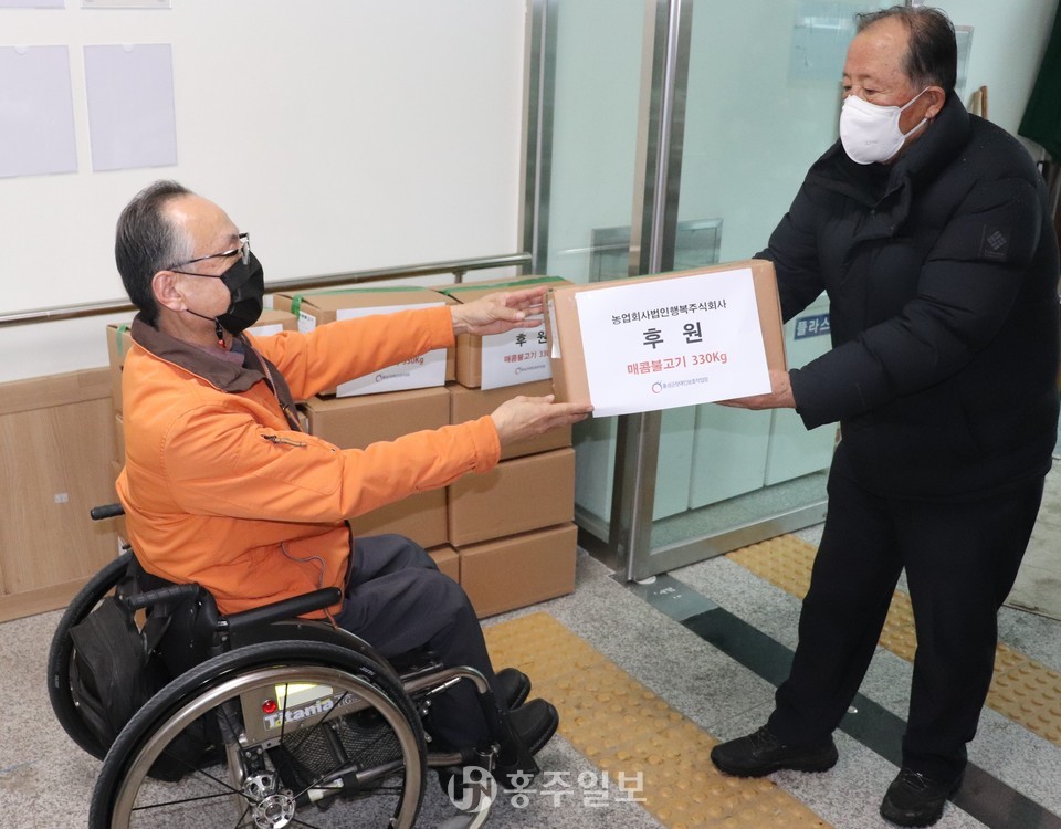 홍성군장애인보호작업장 김호현 원장을 통해 돼지불고기를 전달하는 농업회사법인 행복 윤영우 대표.