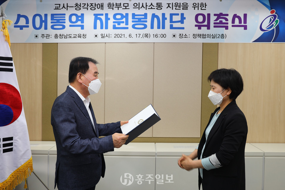 김지철 충남교육감(사진 왼쪽)이 수어통역 자원봉사자에게 위촉장을 수여하고 있다.