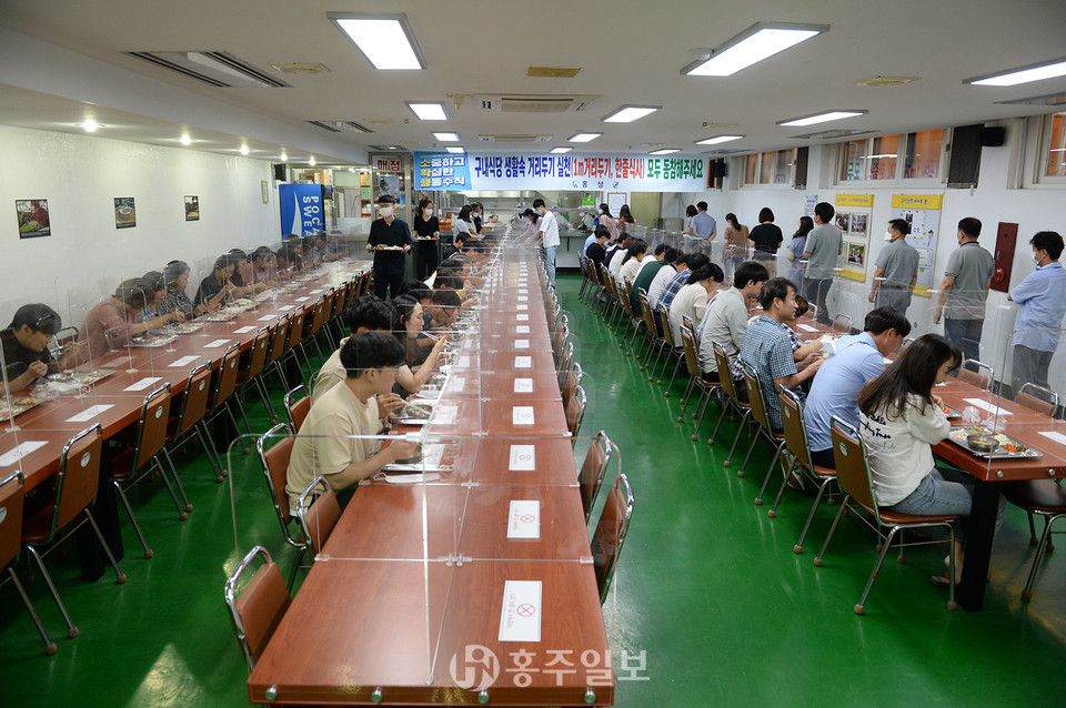 구내식당에 한 줄로 앉아 식사 중인 공무원들의 모습.