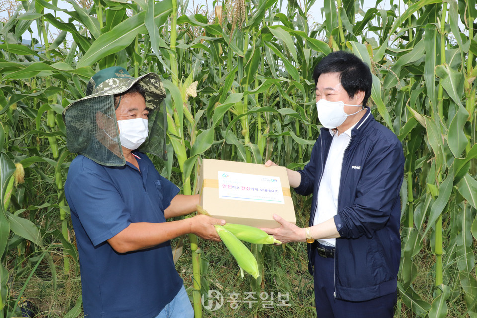 홍성농협 서정훈 상임이사(오른쪽)가 무더위로 지친 농업인을 찾아 식염포도당, 얼음스카프 등으로 구성된 폭염키트를 전달하고 있다.