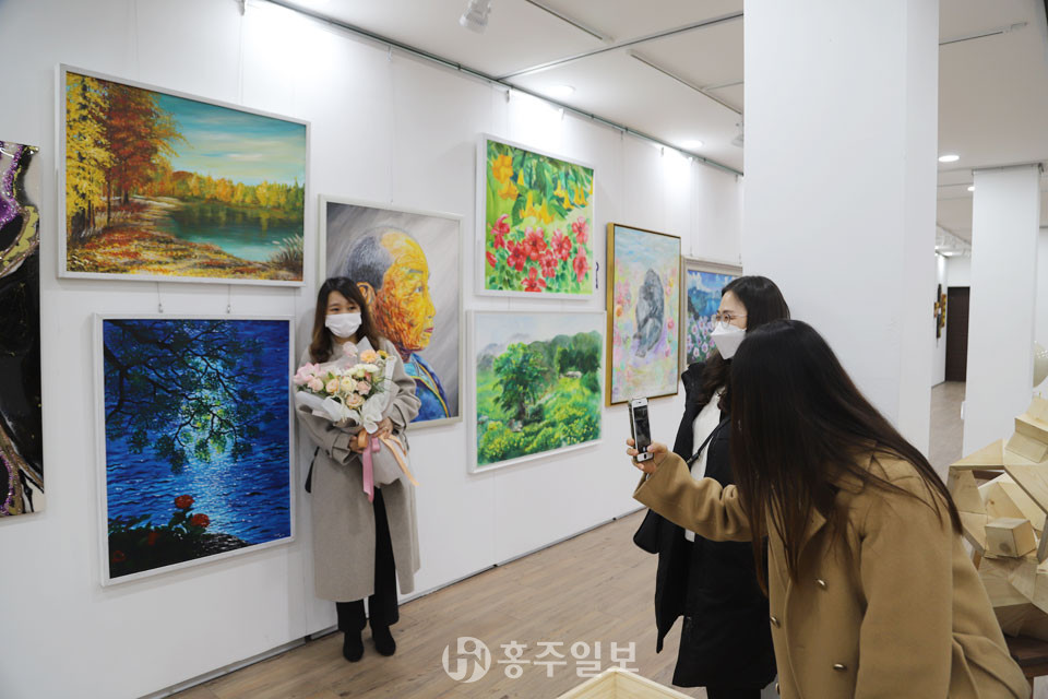 서양화 부문에서 입선한 홍성 근정이 씨를 지인들이 사진을 찍고 있는 모습.