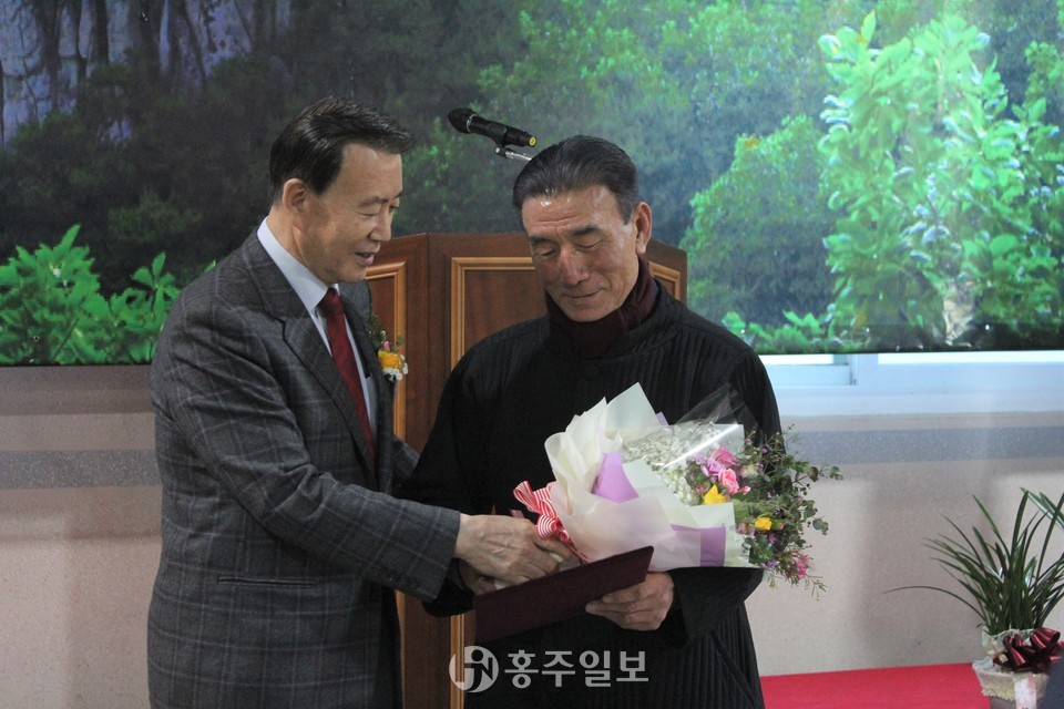 홍문표 국회의원과 국회의원 표창을 받은 전경하 제3대 회장의 모습.