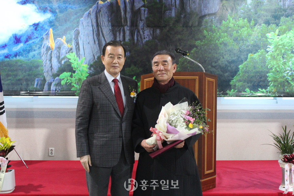 홍문표 국회의원과 국회의원 표창을 받은 전경하 제3대 회장의 모습.