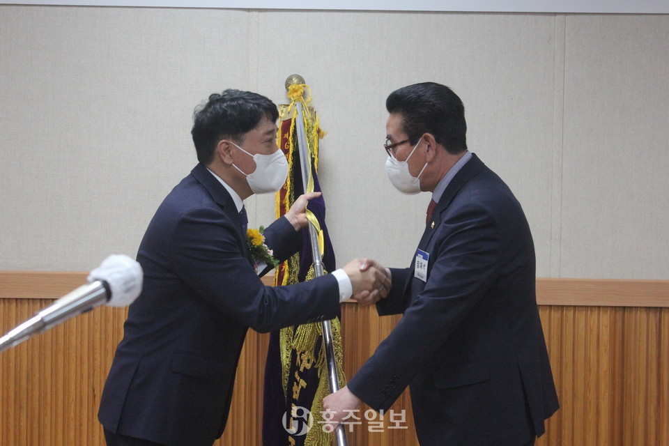 총동창회기를 전달받고 있는 이충수 신임회장.