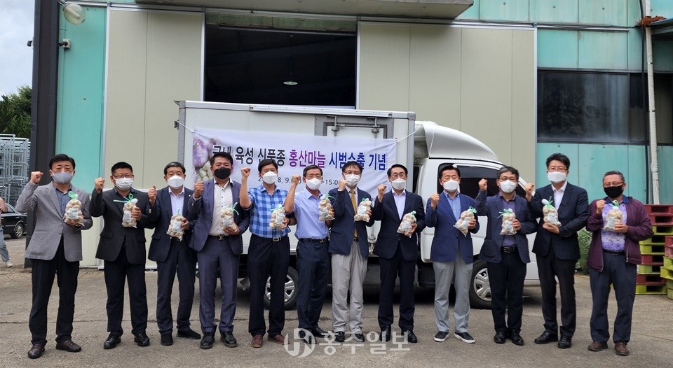 홍산마늘 시범수출 기념 관계자들이 포즈를 취하고 있는 모습.