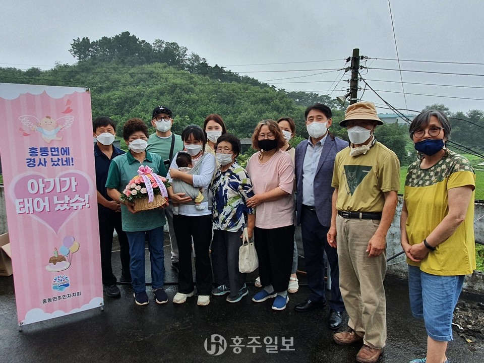 홍동명주민자치회와 주민들이 함께 기념 촬영을 하는 모습.