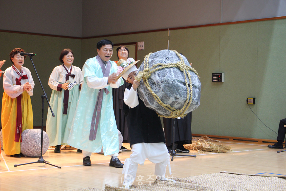 대천마을회의 공연이 한창 진행 중이다. 들돌을 들어 올리고 있는 주인공의 모습.