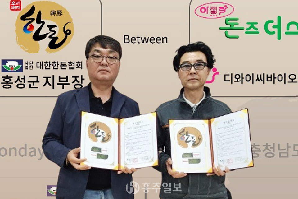 왼쪽부터 김영찬 대한한돈협회 홍성군지부장과 박승훈 디와이씨바이오 대표가 지난 10일 업무협약을 체결했다.