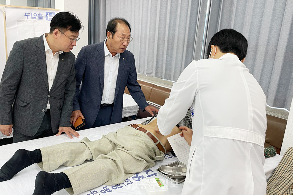 왼쪽부터 이종욱 농협충남세종본부장과 황규진 구항농협조합장이 농업인행복버스에 참여해 진료중인 농업인과 자생한방병원 의료진을 격려하고 있다.