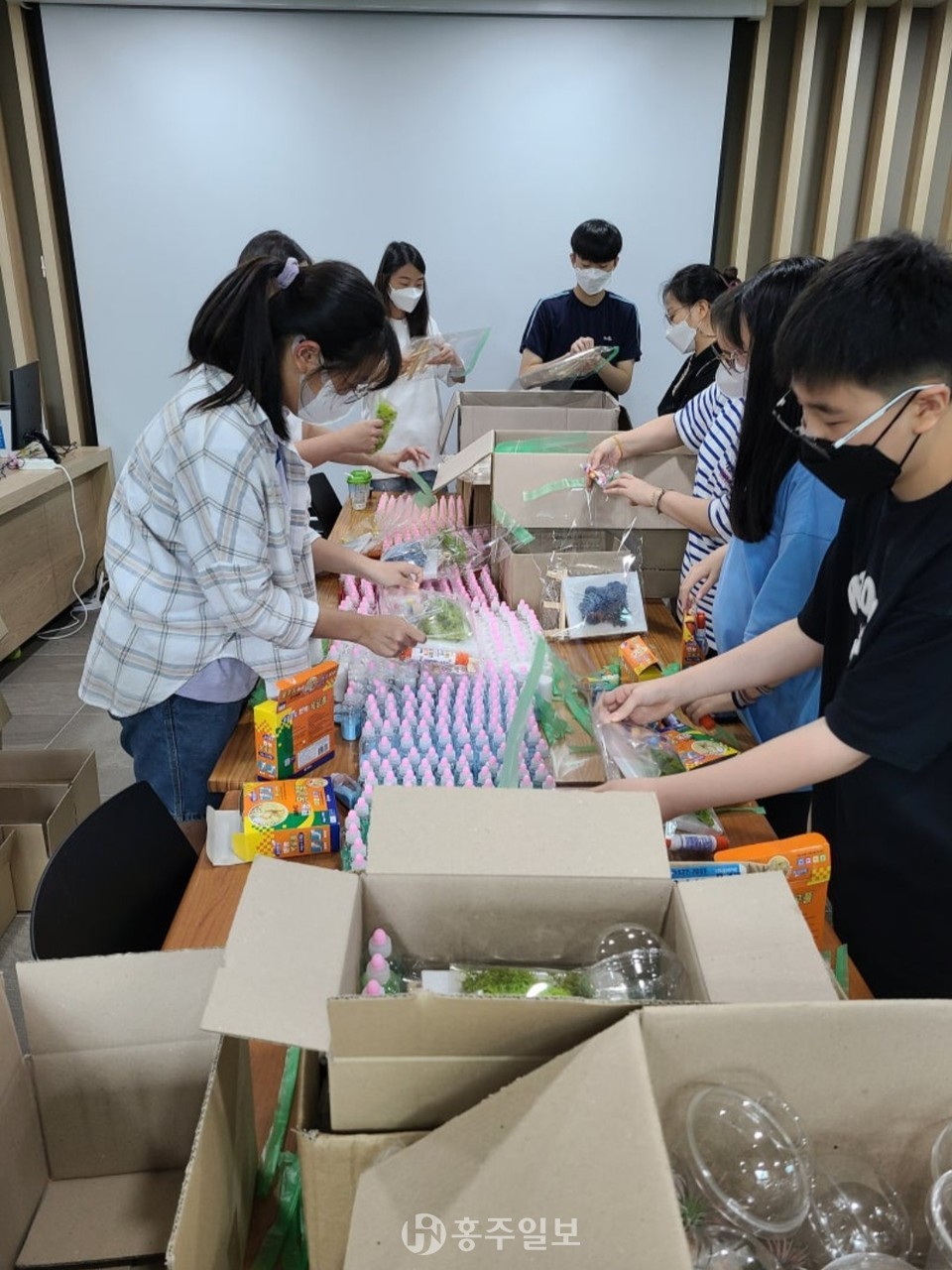 세종특별자치시교육청의 세종마을학교 '꿈이 움트는 디올'의 구성원들이 코로나 펜더믹 시기 세종 새롬동에서 자가 격리를 하고 있던  청소년들에게 제공할 '코로나19 마음 힐링 DIY키트'를  포장하고 있다.