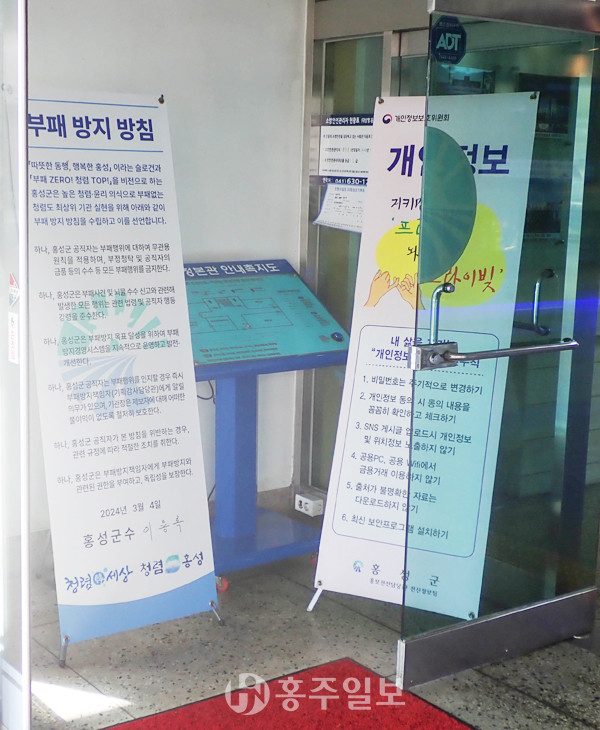 지난달 31일 홍성군청 본관 출입구 구석에 입식 현수막으로 가로막혀 있는 점자안내판.