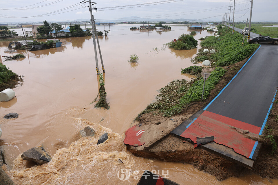 예산 신암면 구만교 인근 삽교천 둑이 무너져 삽교읍 하포리 주택과 농지가 침수된 모습. 얼마 전 조성한 자전거 도로가 유실된 모습도 보인다.